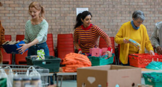 An image of helpers arranging donations of food at a food bank