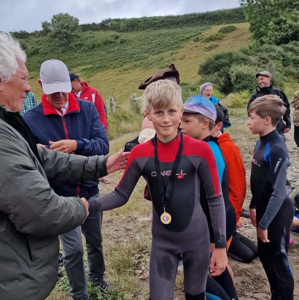 An image of young people in wet suits receiving medals after taking part in the Children's Sailing Trust Inter School Regatta