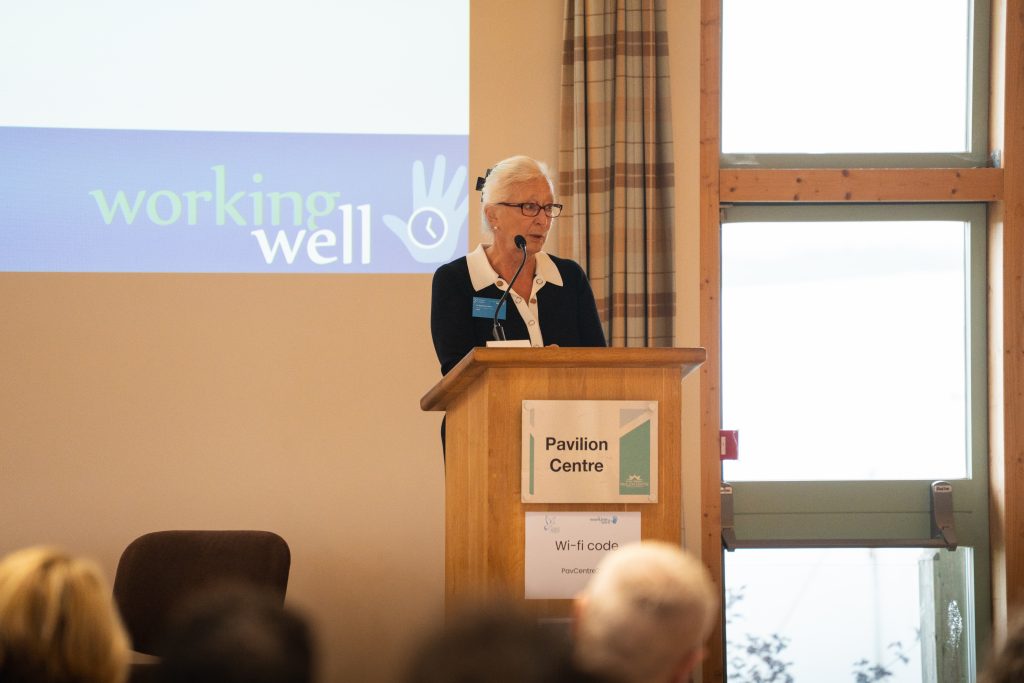 An image of Dr Barbara Vann, Chair of Duchy Health Charity, speaking at a conference, stood behind a lectern.