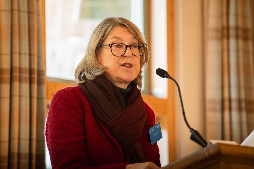 Am image of Sarah Newton, Chair of the Health and Safety Executive, speaking in a microphone at a conference